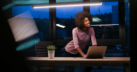 Image showing black businesswoman using a laptop in night startup office