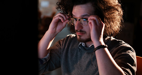 Image showing man working on computer in dark office