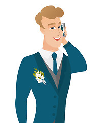 Image showing Young caucasian groom talking on a mobile phone.