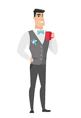 Image showing Young caucasian groom holding cup of coffee.