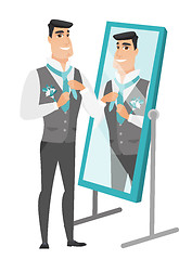 Image showing Groom looking in the mirror and adjusting tie.