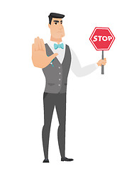 Image showing Caucasian groom holding stop road sign.