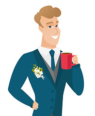 Image showing Young caucasian groom holding cup of coffee.