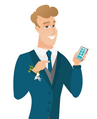 Image showing Young caucasian groom holding a mobile phone.