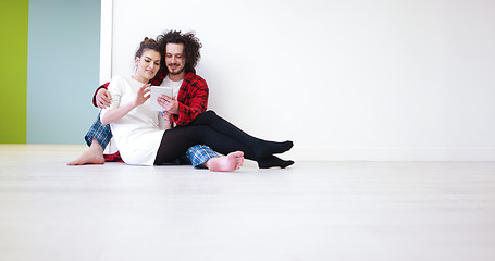 Image showing Young Couple using digital tablet on the floor