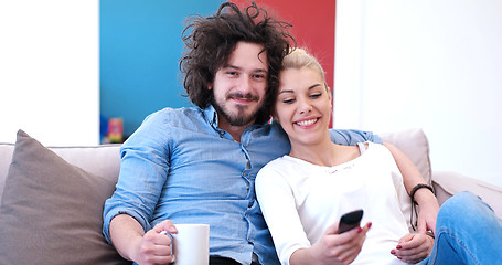 Image showing Young couple on the sofa watching television