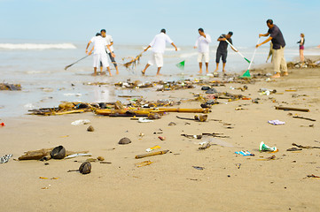 Image showing People cleaning polluted beach. Bali