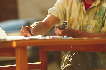 Image showing Close up man working of Architect sketching a construction project on his plane project at site construction work