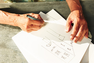 Image showing Close up man working of Architect sketching a construction project on his plane project at site construction work