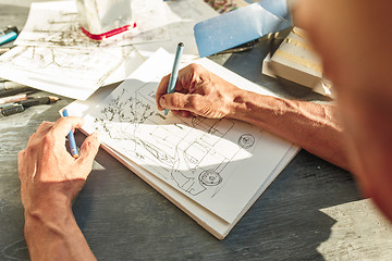 Image showing Close up man working of Architect sketching a construction project on his plane project at site construction work