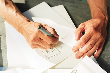 Image showing Close up man working of Architect sketching a construction project on his plane project at site construction work