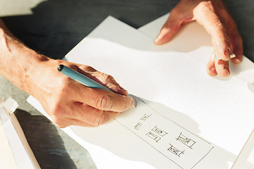 Image showing Close up man working of Architect sketching a construction project on his plane project at site construction work