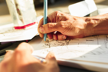 Image showing Close up man working of Architect sketching a construction project on his plane project at site construction work