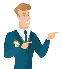 Image showing Young caucasian groom pointing to the side.