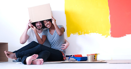 Image showing young multiethnic couple playing with cardboard boxes