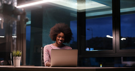 Image showing black businesswoman using a laptop in night startup office