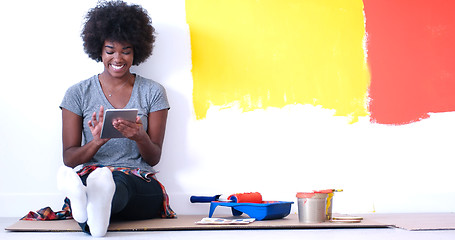 Image showing black female painter sitting on floor