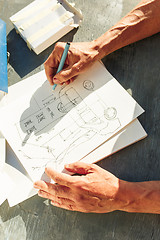 Image showing Close up man working of Architect sketching a construction project on his plane project at site construction work