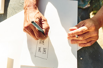 Image showing Close up man working of Architect sketching a construction project on his plane project at site construction work