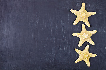 Image showing Top view of three starfish on black background.