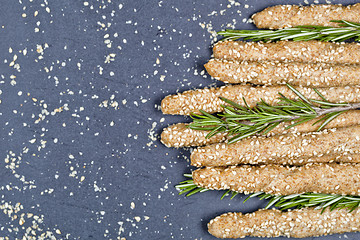 Image showing Italian grissini bread sticks with sesame and rosemary herb on b