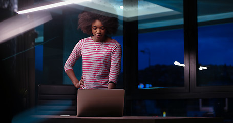 Image showing black businesswoman using a laptop in night startup office