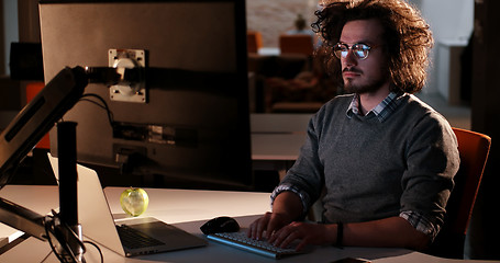 Image showing man working on computer in dark office