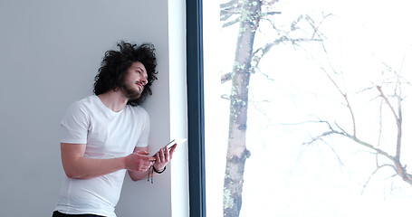 Image showing young man using a tablet at home