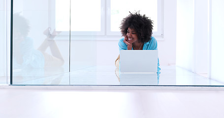 Image showing black women using laptop computer on the floor