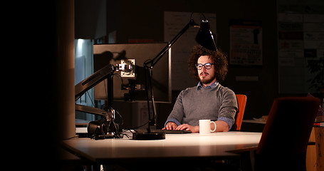 Image showing man working on computer in dark office