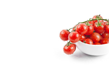 Image showing Fresh organic wet cherry tomatoes bunch on ceramic bowl.