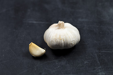 Image showing Fresh raw organic garlic on black board.