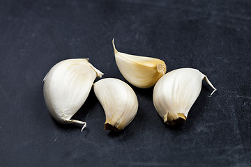 Image showing Fresh raw organic garlic on black board.