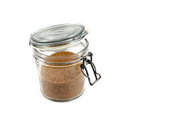 Image showing Brown cane sugar in glass jar isolated on white background. 