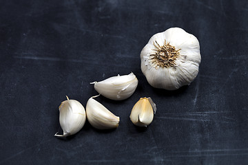 Image showing Fresh raw organic garlic on black board.
