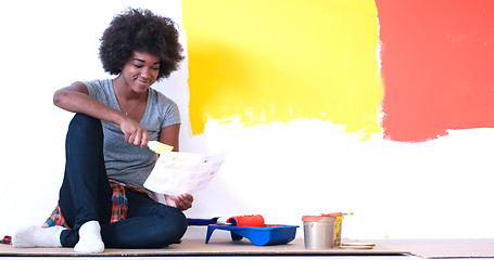 Image showing black female painter sitting on floor