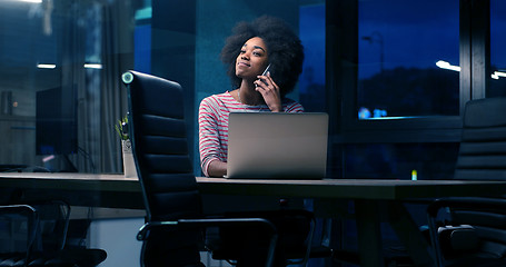 Image showing black businesswoman using a laptop in night startup office