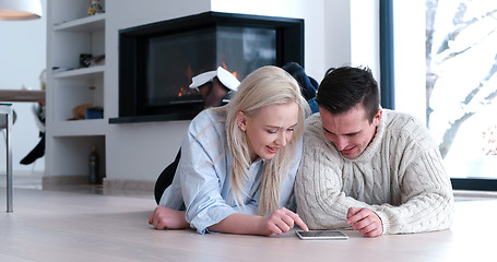 Image showing Young Couple using digital tablet on the floor