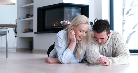 Image showing Young Couple using digital tablet on the floor