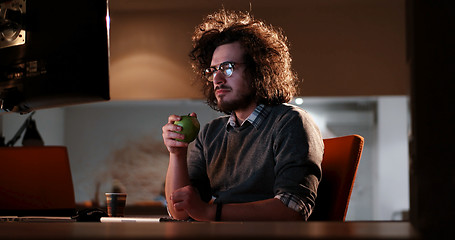 Image showing man working on computer in dark office