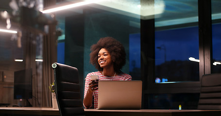 Image showing black businesswoman using a laptop in night startup office