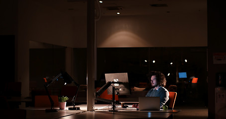 Image showing man working on computer in dark office