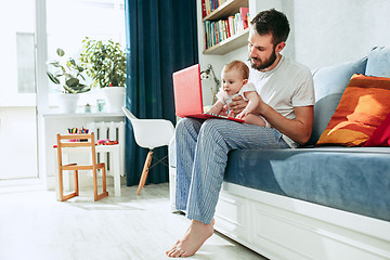 Image showing Proud father holding his baby daughtesr at home