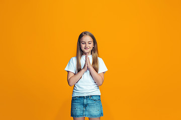 Image showing Beautiful teen girl looking suprised isolated on orange