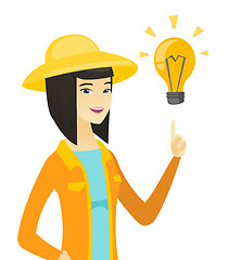 Image showing Young asian farmer pointing at idea light bulb.