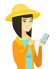 Image showing Young asian farmer holding a mobile phone.