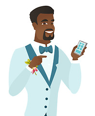 Image showing African-american groom holding a mobile phone.