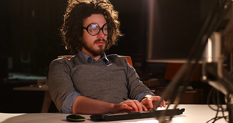 Image showing man working on computer in dark office