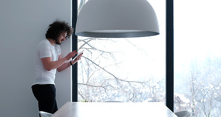 Image showing young man using a tablet at home