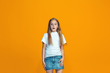 Image showing Beautiful teen girl looking suprised isolated on orange